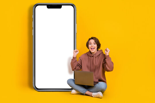 Full body photo of young astonished woman celebrate new betting app for gambling online netbook monitor isolated on yellow color background