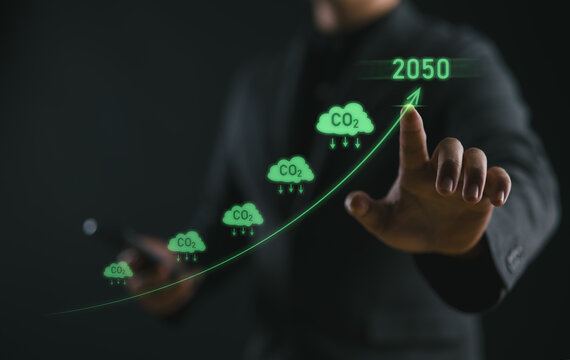 Businessman point to increasing arrow with carbon reduction for decrease CO2, carbon footprint and carbon credit to limit global warming from climate change, Bio Circular Green Economy concept..