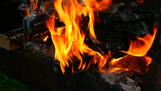burning wood and paper. firewood is burning. tongues of flame. orange flame. bonfire. wood-fired cooking. firewood is burning for cooking barbecue
