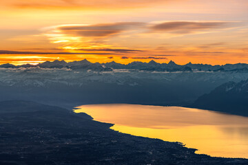 Colourful morning sky with Cirrus clouds above Swiss Alps with lake