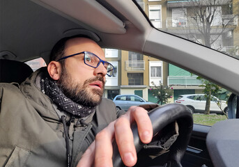 Uomo sexy alla guida della propria automobile in città - obrazy, fototapety, plakaty