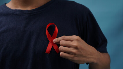 man holding red ribbon on his chest supporting world awareness day