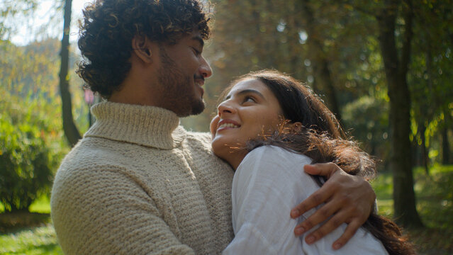 Happy married couple in love african american man indian woman husband wife hugging embrace hug cuddling in park outdoors romantic date in nature loving affection family relationship enjoying together