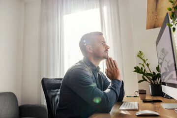 A worried entrepreneur is looking at computer at home.