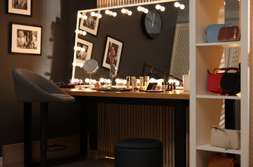 Makeup room. Stylish mirror on dressing table with different beauty products