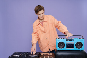 DJ Teenager holding boombox using  turntable on the purple background