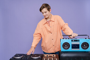 DJ Teenager holding boombox using  turntable on the  background