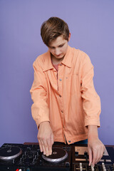 Teenager dj playing music in studio on  color background
