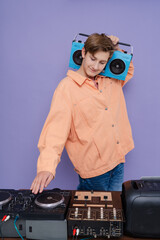 Cool charming boy hold boom box on his shoulder want listen vintage music isolated over bright color background