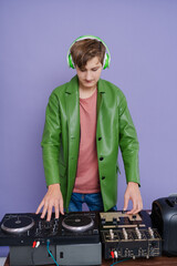 Teenage DJ playing music on a turntable  isolated on lilac 
 background