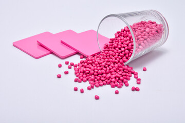 pink masterbatch granules with color chips as an example of the color produced, isolated on a white...