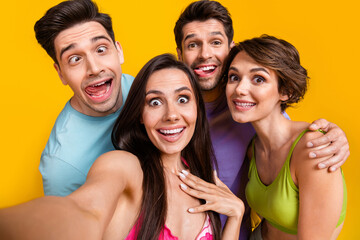 Photo of carefree positive people friends make selfie doing grimace face stick tongue out isolated bright color background