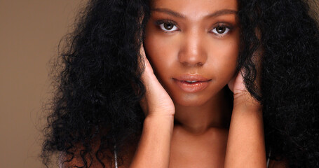 Portrait of a black girl with curly hair, soft makeup and perfect skin. Beautiful face of young...