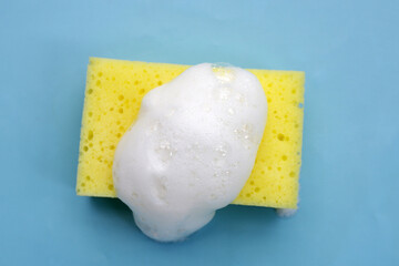 Cleaning sponge with foam of dishwashing liquid. Washing dishes concept