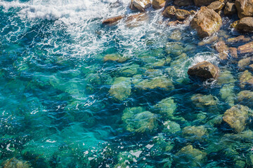 Landscape with transparent Mediterranean sea water with rocks underwater and foam, ITALY