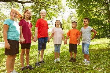 Children holding hands standing at park