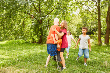 Obraz premium Children embracing disabled friend at park