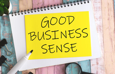 text GOOD BUSINESS SENSE on yellow paper composition with stationery on color background