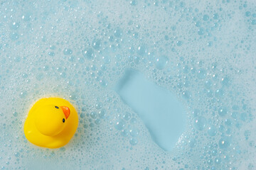 Yellow rubber duck floating on blue water