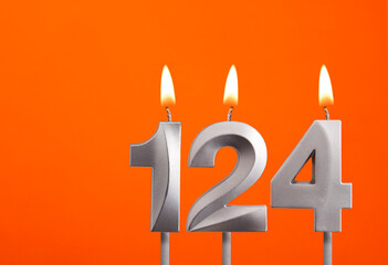 124 candle - Birthday celebration on orange background