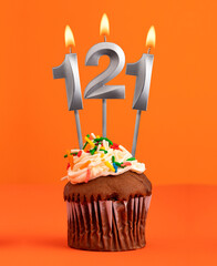 Birthday cupcake with number 121 candle - Orange color background