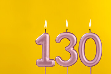 Birthday candle number 130 - Birthday celebration on yellow background - obrazy, fototapety, plakaty