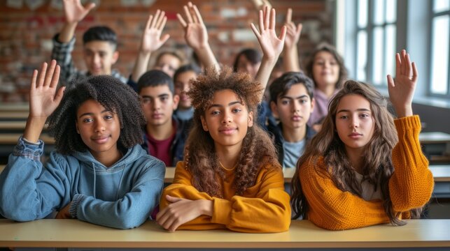 Multiethnic group of students raising hands in class
