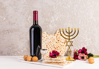 Beautiful festive still life for the Jewish Passover holiday. Front view of traditional foods, kosher wine in glass bottle , candlestick menorah