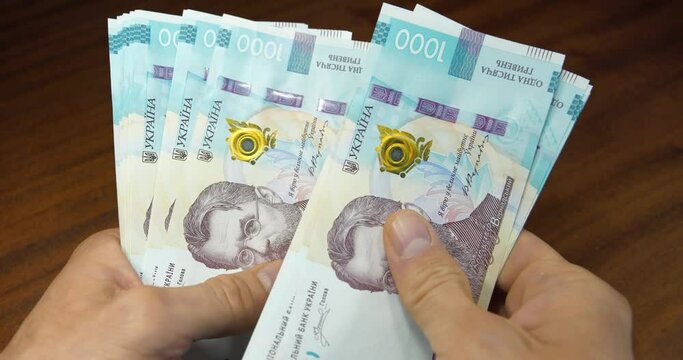Cash counting. Man holds thousand hryvnia bills in his hands. Hands holds banknotes. Converting cash Ukrainian money. New paper thousand hryvnia bills. Currency exchange. Monetary policy. Global trade