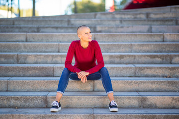 Full body female with short hair siting on steps © mimagephotos