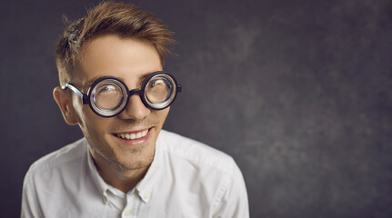 Closeup studio portrait of funny nerd wearing retro vintage thick rimmed glasses on copyspace...