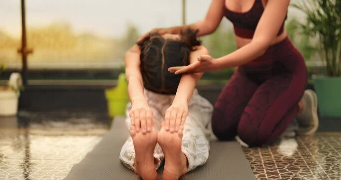 Indian Asian Hindu happy adult woman sitting mat do toe touch yoga gym workout sport class day outdoor home young female lady teach stretch warm up teen girl child learn self heath care good habit