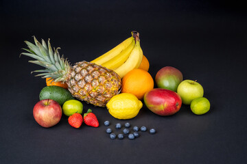 Still life with variety of fresh and ripe fruits arranged on a dark background. Fitness concept, diet, healthy lifestyle. Concept for elegant presentation of healthy food..