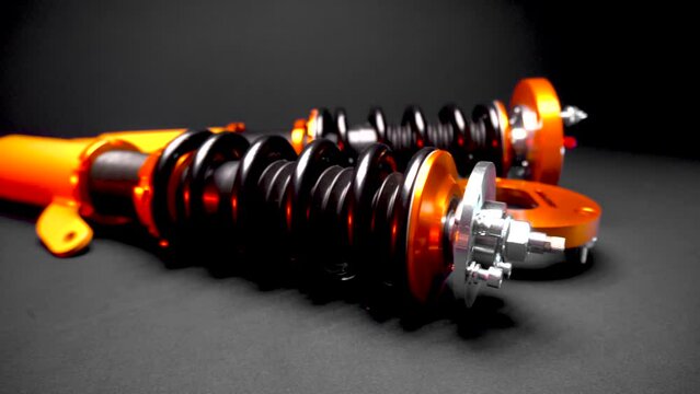 suspension tuning, coilovers, shock absorbers and front springs in yellow and gold colors for a sports drift car on a dark background