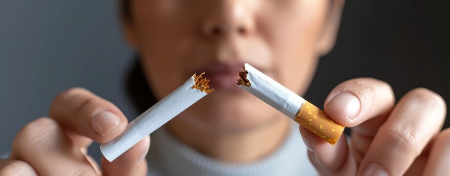 Woman breaking a cigarette in half. Stop smoking concept.