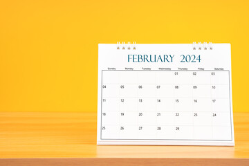 February 2024, Monthly desk calendar for 2024 year on wooden table.
