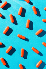 Orange capsule pills on blue background
