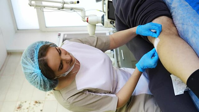 Medical young worker doing wound treatment and removing stitches. Vertical video