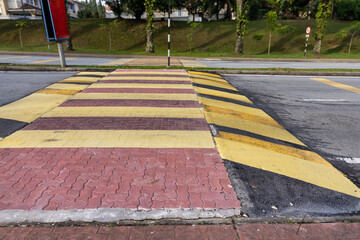 Speed bump or road hump in yellow and black stripe to slow down vehicles and promote road safety