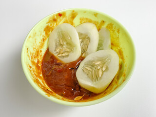 Rujak, traditional salad from Indonesia, consist of cucumber slices and sambal rujak or spicy salad dressing paste. Isolated on white background