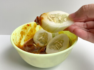 Rujak, traditional salad from Indonesia, consist of cucumber slices and sambal rujak or spicy salad dressing paste. Isolated on white background
