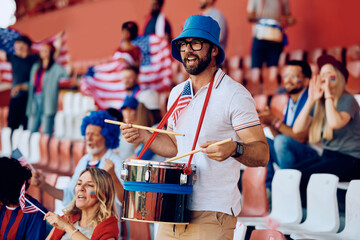 USA sports fan playing drums during match at stadium.