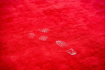 White shoe marks on a bright red carpet