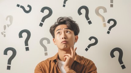 Pensive Young Man Surrounded by Question Marks, Symbolizing Curiosity and Confusion