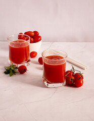 Tomato juice in a glass and fresh tomatoes. on a white background. food
