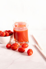 Tomato juice in a glass and fresh tomatoes. on a white background. food