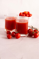 Tomato juice in a glass and fresh tomatoes. on a white background. food