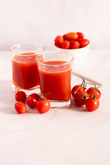 Tomato juice in a glass and fresh tomatoes. on a white background. food