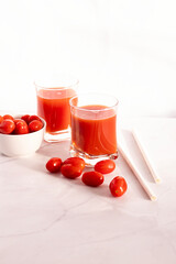 Tomato juice in a glass and fresh tomatoes. on a white background. food