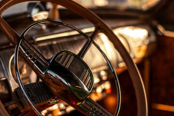 Detail of the steering wheel and dashboard of a classic car.